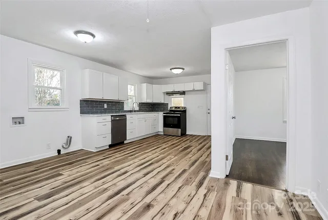 a kitchen with a refrigerator and white cabinets