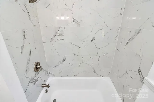 a bathroom with bathtub and shower