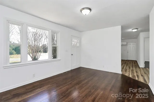 a view of a room with wooden floor and a window