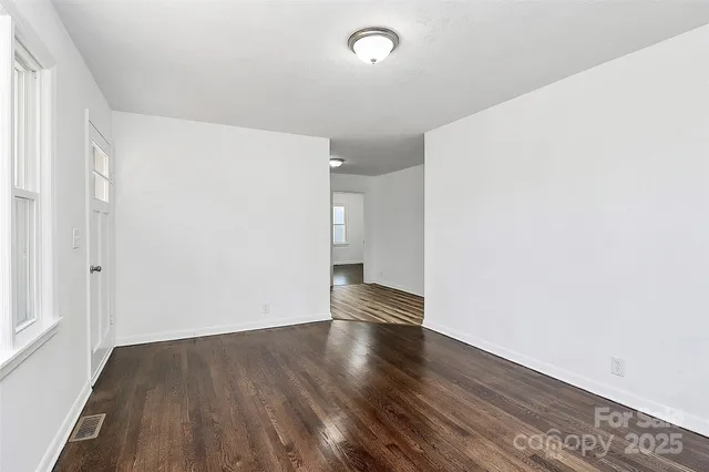 a view of empty room with wooden floor