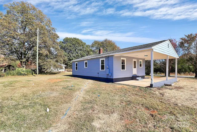a view of a house with backyard and sitting area
