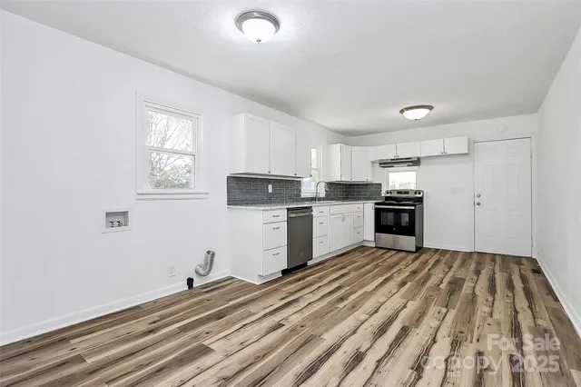 a kitchen with white cabinets and appliances