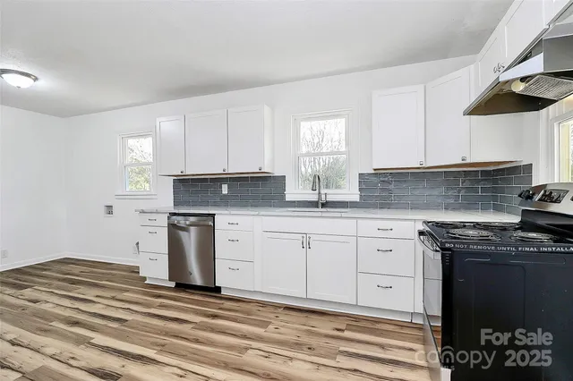 a kitchen with granite countertop white cabinets and stainless steel appliances