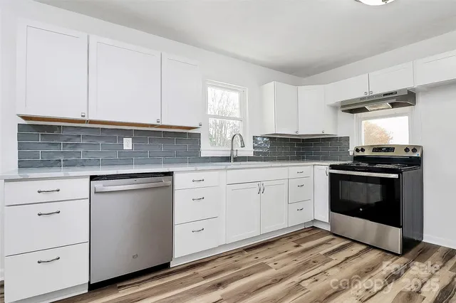 a kitchen with granite countertop white cabinets and white appliances