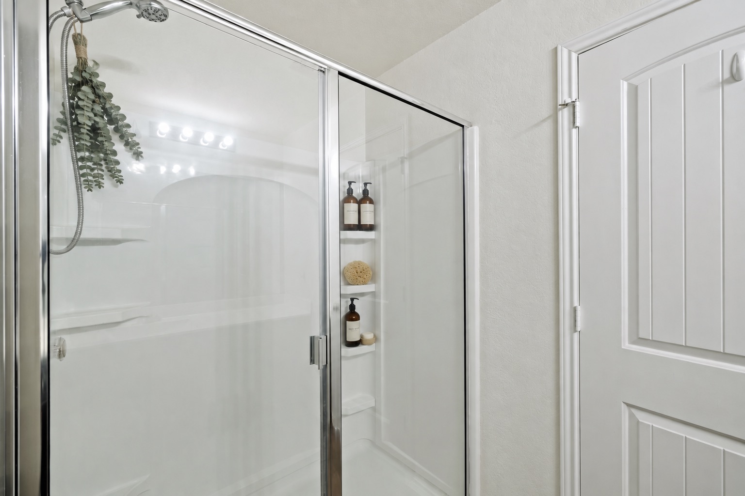 15011 Tuff Rd Manor Manor, TX 78653 - Photo 27 of 37 Virtually staged walk-in shower with a glass door, handheld showerhead, and built-in corner shelves in the primary bathroom.