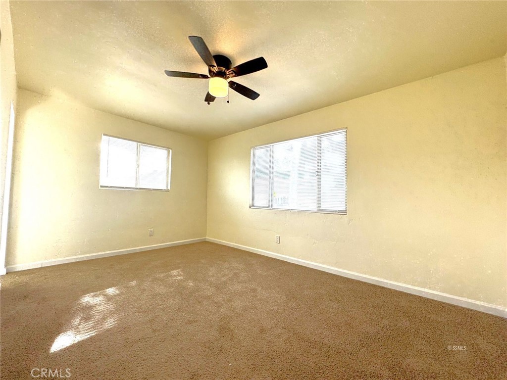 1500 West Alene Avenue Ridgecrest, CA 93555 - Photo 13 of 30 a view of a big room with windows and chandelier fan