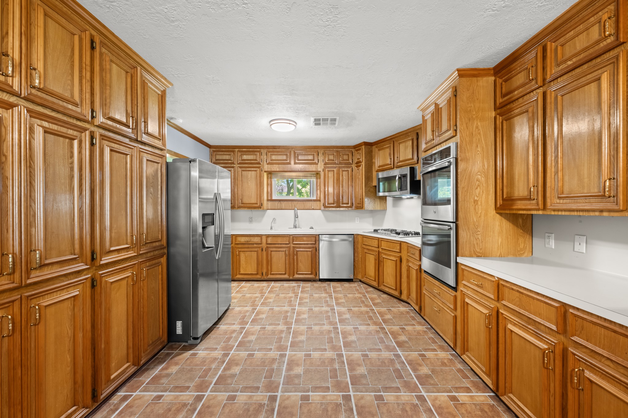 616 Cannan Drive Angleton, TX 77515 - Photo 10 of 49 Designed with both functionality and storage in mind, this spacious kitchen features abundant custom cabinetry, expansive counter space, and stainless steel appliances. The efficient layout, generous workspace, and ample storage make meal preparation and organization effortless.
