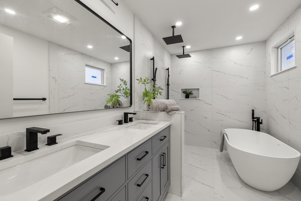 27 Coolidge Road, Unit 1 Boston, MA 02134 - Photo 17 of 41 a bathroom with a double vanity sink a mirror and a bathtub
