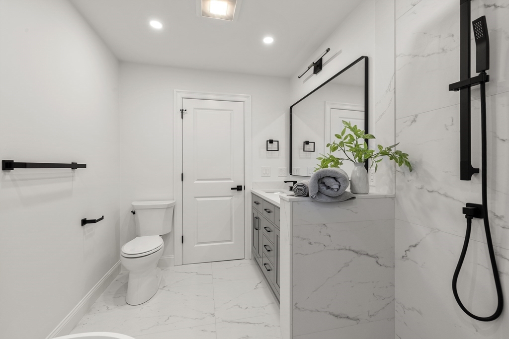 27 Coolidge Road, Unit 1 Boston, MA 02134 - Photo 18 of 41 a bathroom with a granite countertop sink a toilet and a shower