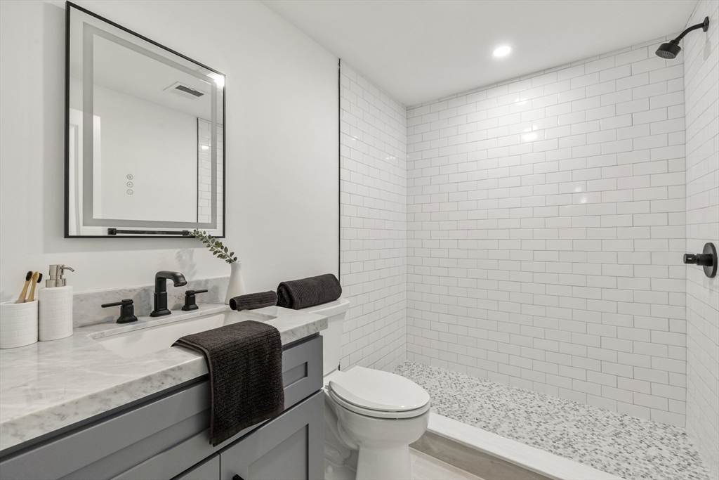 27 Coolidge Road, Unit 1 Boston, MA 02134 - Photo 31 of 41 a bathroom with a sink a toilet and mirror