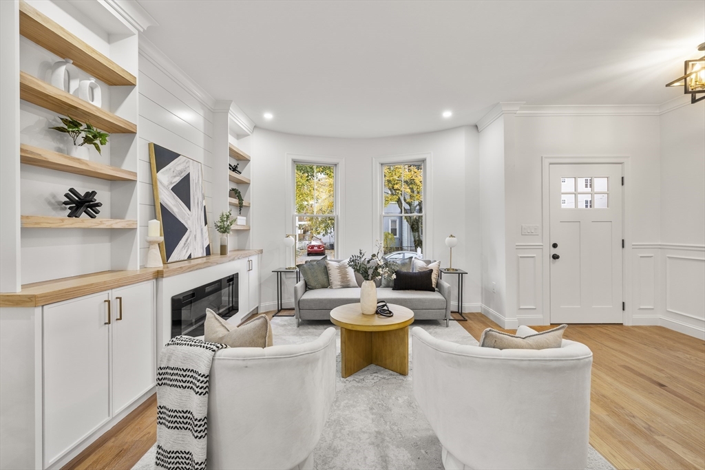 27 Coolidge Road, Unit 1 Boston, MA 02134 - Photo 5 of 41 a living room with furniture a fireplace and a large window