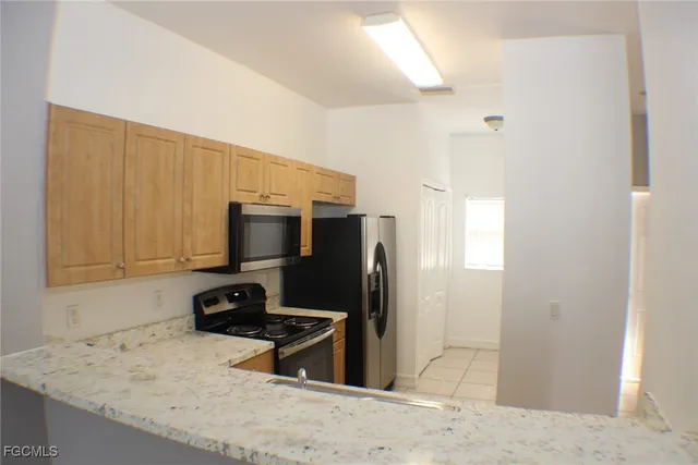 a kitchen with stainless steel appliances granite countertop a refrigerator a stove and a sink