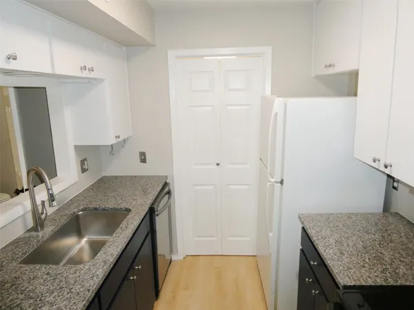a bathroom with a granite countertop sink a washer and dryer