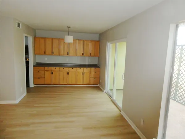an empty room with wooden door and windows