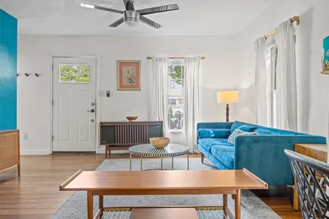 a living room with furniture a rug and a window