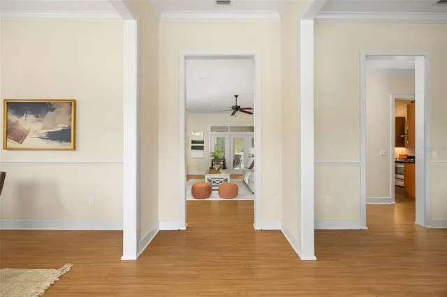 a view of a hallway with wooden floor and a living room