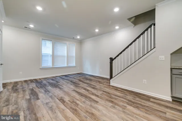a view of an empty room with stairs and a window