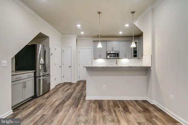 a view of a kitchen with a sink and dishwasher a refrigerator with wooden floor