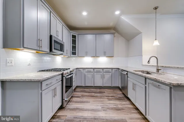 a kitchen with stainless steel appliances granite countertop a sink and stove top oven