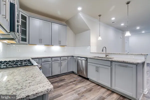 a kitchen with granite countertop stainless steel appliances sink stove and cabinets