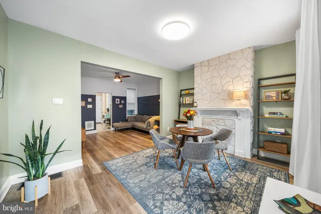 a living room with furniture a large window and a wooden floor