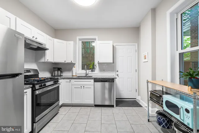 a kitchen with stainless steel appliances a stove a sink and a refrigerator