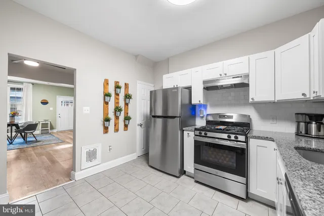 a kitchen with stainless steel appliances granite countertop a stove a refrigerator and a cabinets