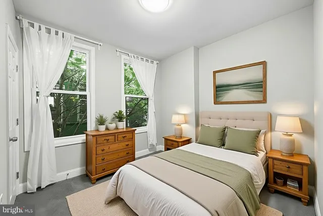 a bedroom with a bed and a large window