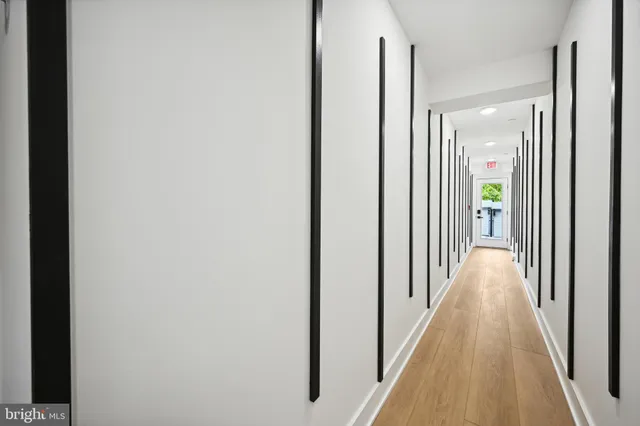 a view of a hallway with wooden floor and staircase