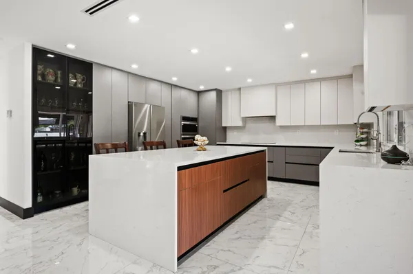 a kitchen with stainless steel appliances kitchen island granite countertop a refrigerator and a sink