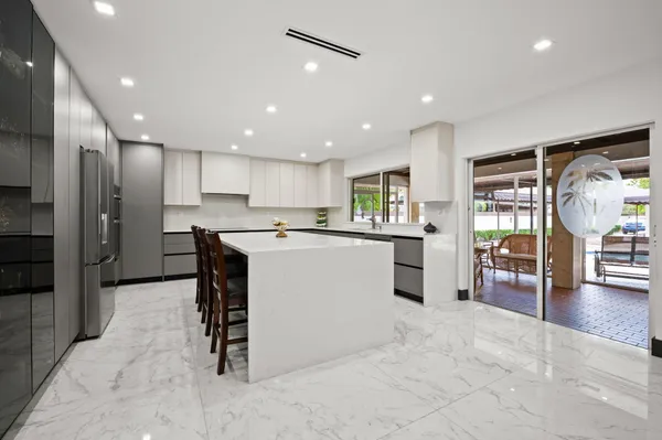 a kitchen with stainless steel appliances kitchen island granite countertop a refrigerator and a stove
