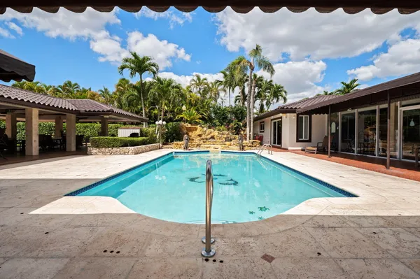a view of a house with swimming pool and porch with furniture