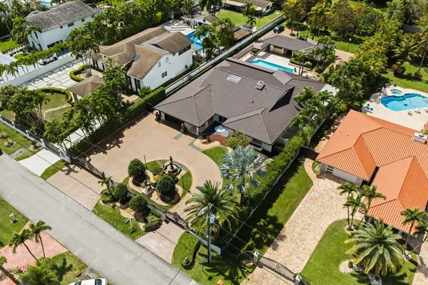 an aerial view of residential houses with outdoor space and trees