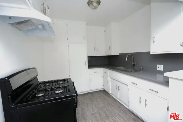 a kitchen with granite countertop white cabinets and stainless steel appliances