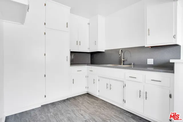 a kitchen with granite countertop white cabinets and white appliances