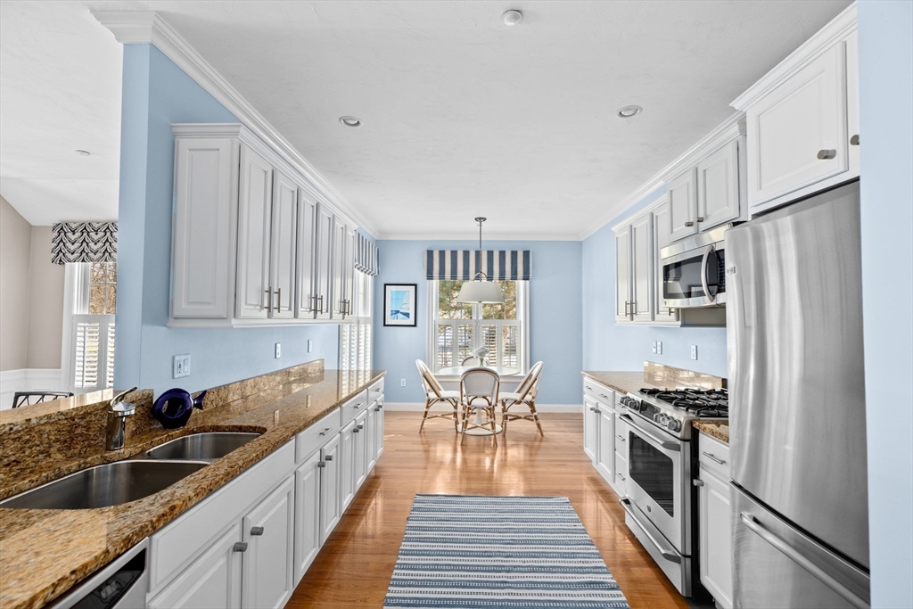 239 Washington Street, Unit 9 Norwell, MA 02061 - Photo 9 of 27 a kitchen with stainless steel appliances granite countertop a refrigerator and a stove top oven