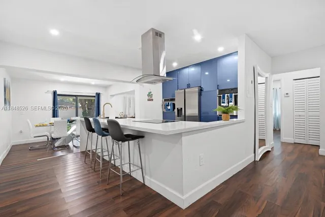 a kitchen with stainless steel appliances a refrigerator and wooden floor