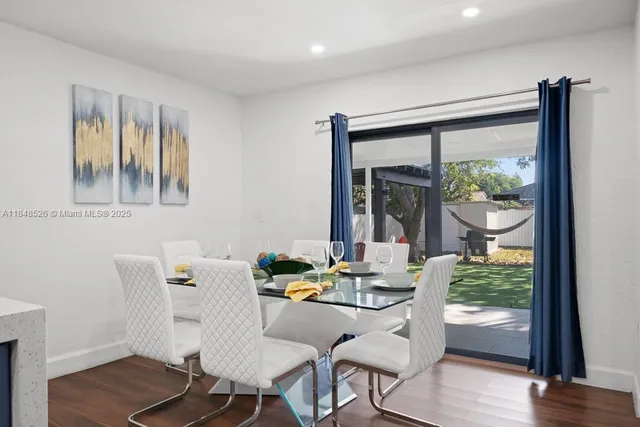 a dining room with furniture window and wooden floor