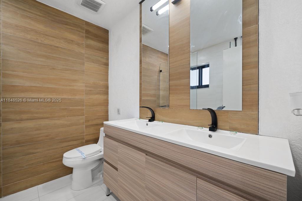 445 Southwest 62nd Court Miami, FL 33144 - Photo 18 of 41 a bathroom with a sink a toilet and mirror