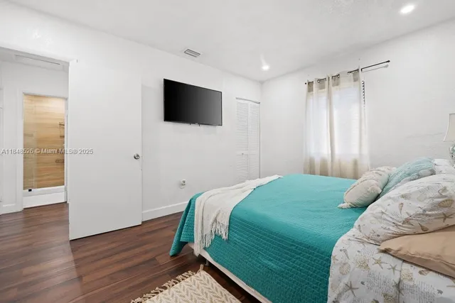 a bedroom with a bed and a flat screen tv