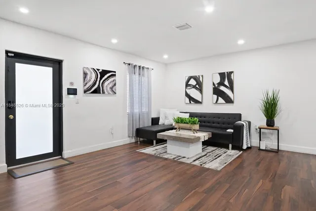 a living room with furniture and a wooden floor