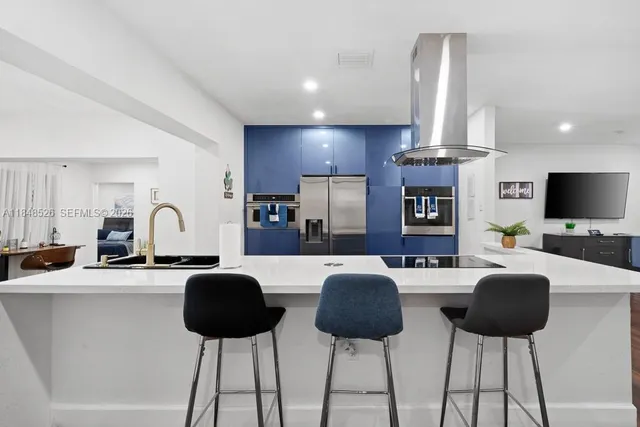 a living room with furniture a flat screen tv and kitchen view