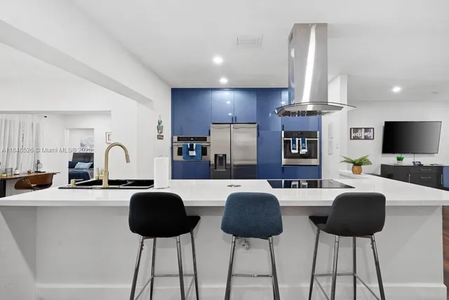 a living room with furniture a flat screen tv and kitchen view