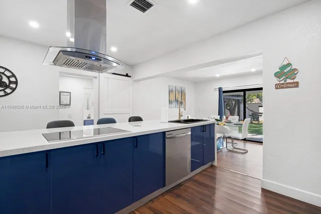 a kitchen with a sink cabinets and wooden floor