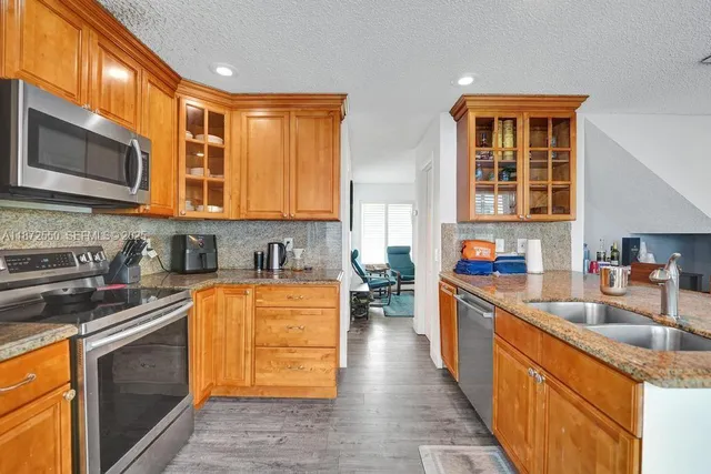 a kitchen with stainless steel appliances granite countertop a stove a sink and a microwave