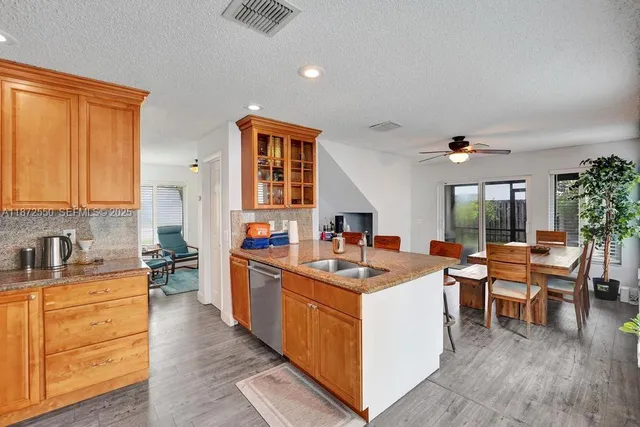 a kitchen that has a lot of cabinets in it and wooden floors