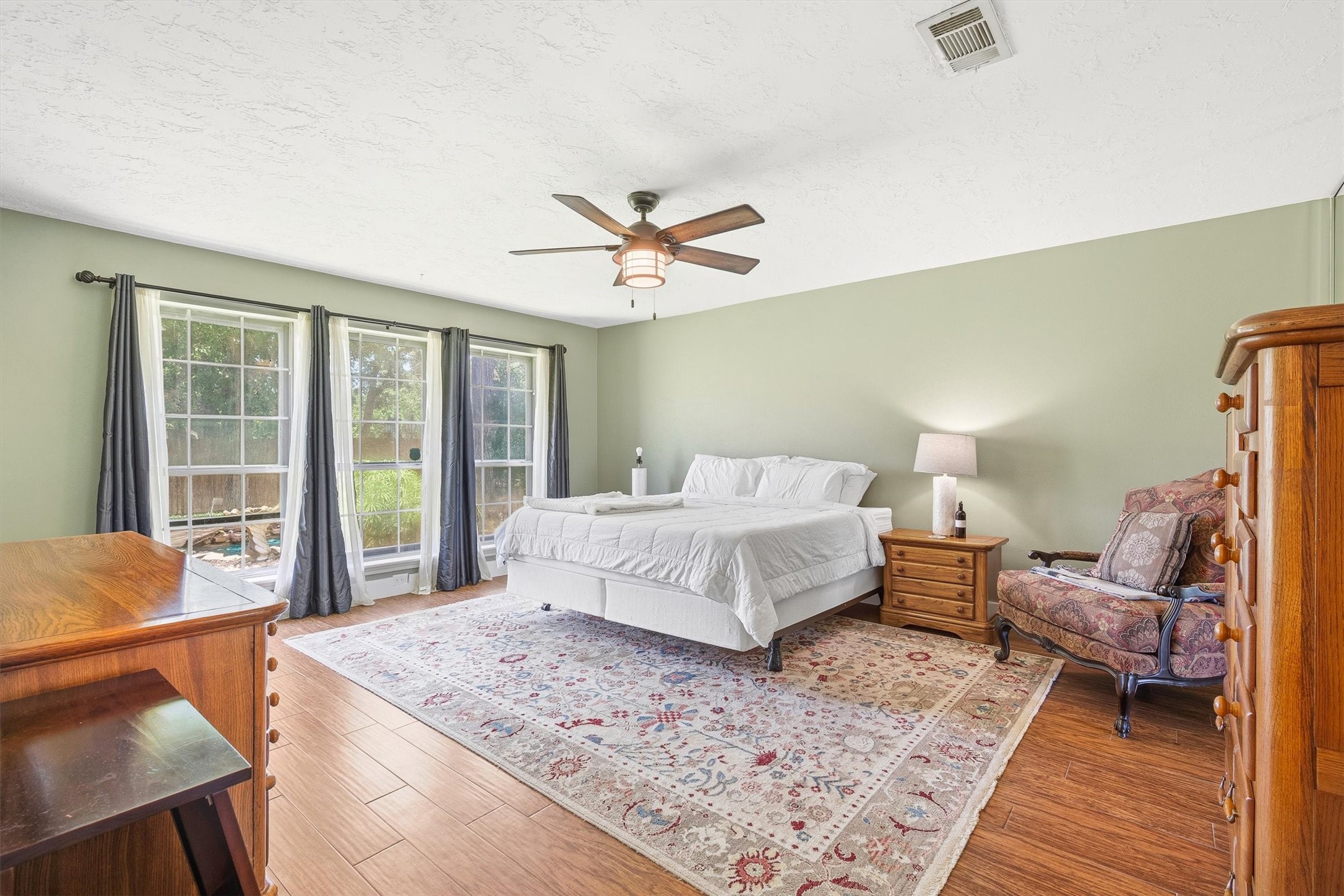 826 North Rivershire Drive Conroe, TX 77304 - Photo 20 of 46 This angle shows just how much natural light the primary bedroom pulls in through those large windows overlooking the backyard. There is real room to breathe here — this is not a bedroom you will feel crowded in.