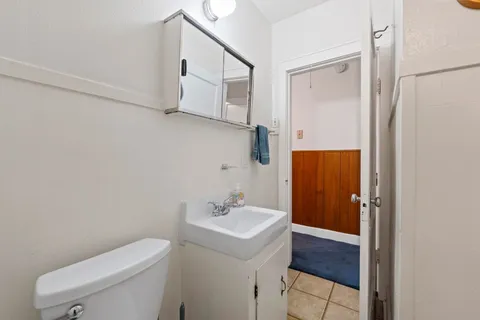a bathroom with a toilet a sink and mirror