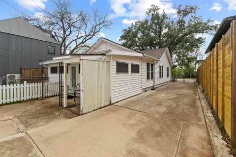 a white house that has tree in front of it