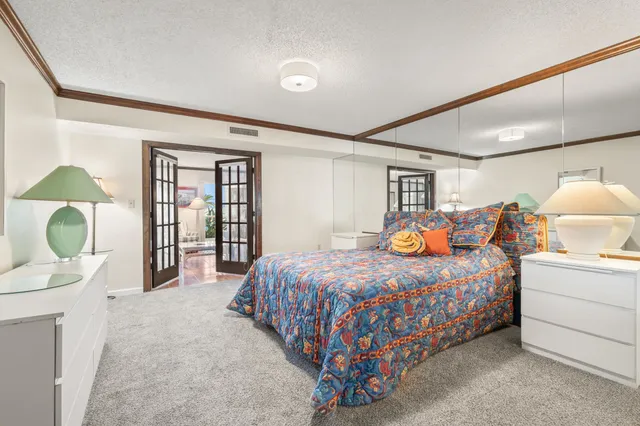 a bedroom with a bed mirror and window